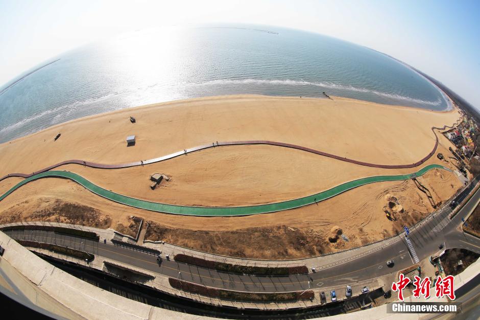 3月13日，秦皇島萬米臨海沙灘木棧道。據(jù)了解，該木棧道全長約4200米，與北戴河區(qū)原有的7500米木棧道對接后全線總長度1.17萬米，整個木棧道東起秦皇島體育基地游船碼頭，西至北戴河濕地公園，呈波浪形蜿蜒10.4公里海岸線。 中新社發(fā) 曹建雄 攝 CNSPHOTO